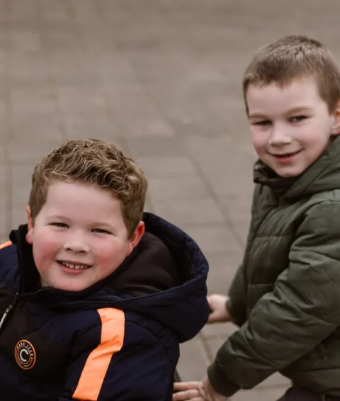Twee jonge basisschool kinderen buiten aan het spelen