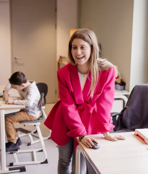 Leraar lacht naar leerling in het basisonderwijs